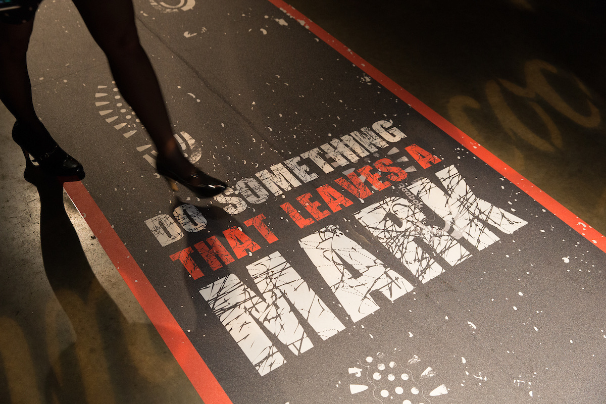 A guest steps over runway type reading Do something that leaves a mark