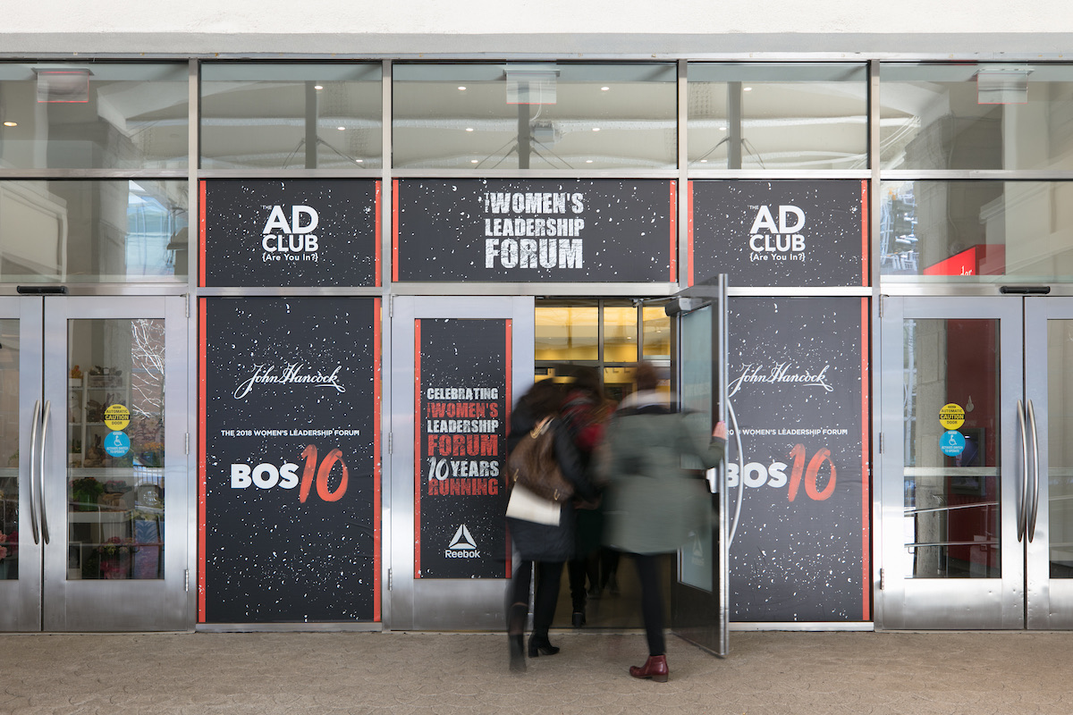 Guests entering through doors wrapped in Women's Leadership Forum graphics